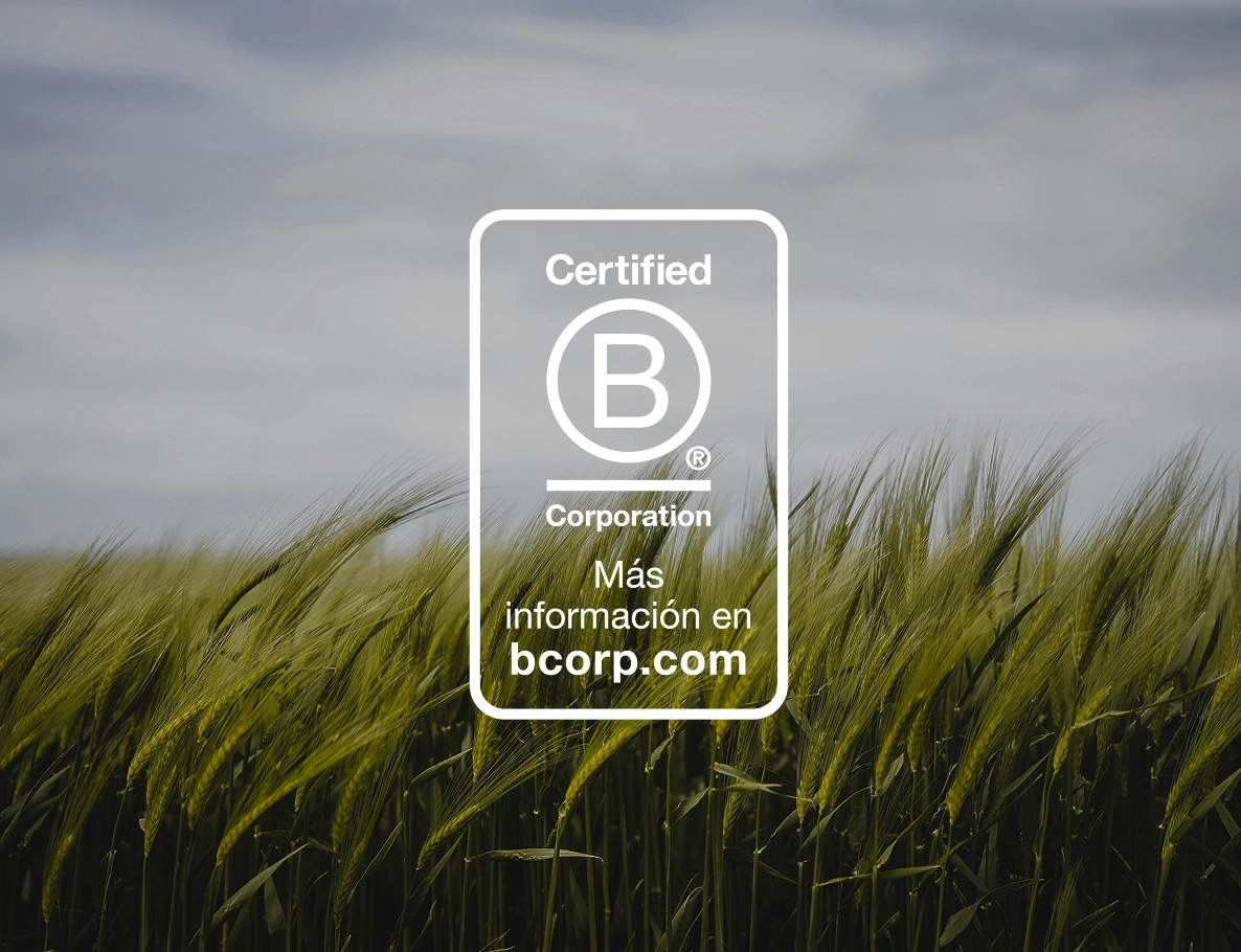 Sello Certified B Corporation sobre un campo de cereal verde.